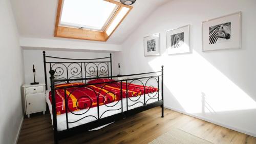 a bedroom with a black bed and a skylight at FeWo Himmeleck, Oberstaufen/Wiedemannsdorf in Oberstaufen