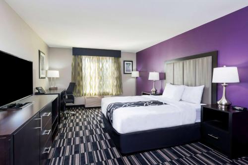 um quarto de hotel com uma cama grande e paredes roxas em La Quinta by Wyndham Fairfield - Napa Valley em Fairfield