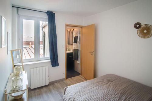 - une chambre avec un lit, une fenêtre et une porte dans l'établissement Charmant T2 à deux pas de la célèbre place Stanislas, à Nancy