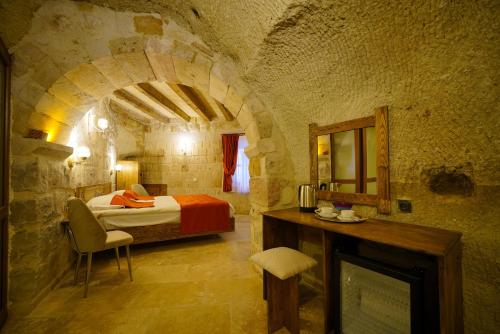 a bedroom with a bed in a stone room at Vezir Cave Suites in Göreme