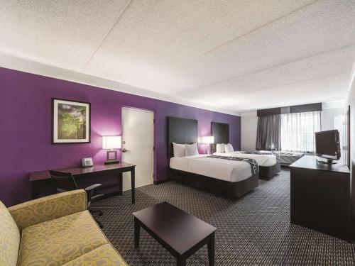 a hotel room with two beds and a couch at La Quinta Inn & Suites by Wyndham San Antonio Downtown in San Antonio