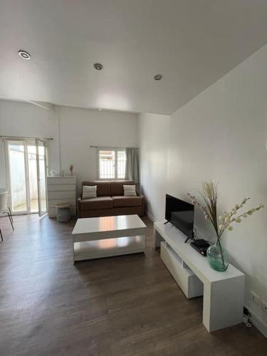 un salon blanc avec un canapé et une télévision dans l'établissement Charmant logement à Romainville, à Romainville