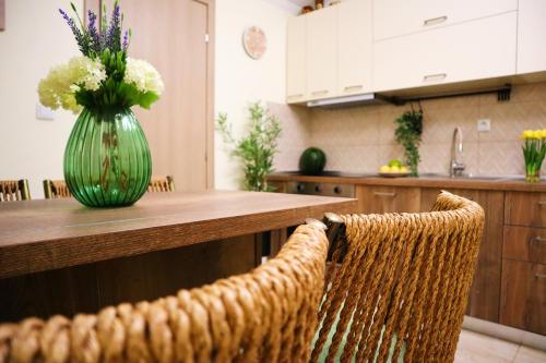 un vase de fleurs assis sur une table dans une cuisine dans l'établissement Thassion-ikea Feels Like Home, à Astris