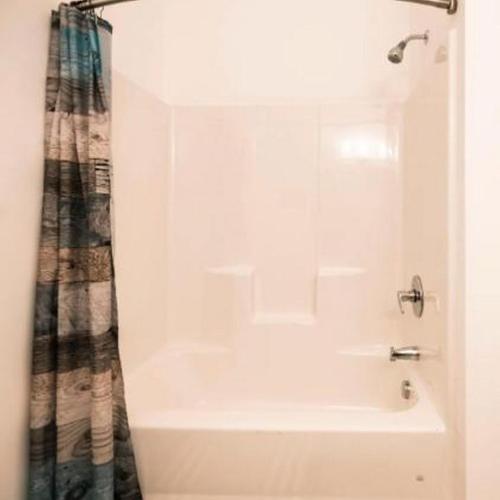 uma banheira branca com uma cortina de chuveiro na casa de banho em Pet Friendly North Shore Studio w/ Fitness Center em Pittsburgh