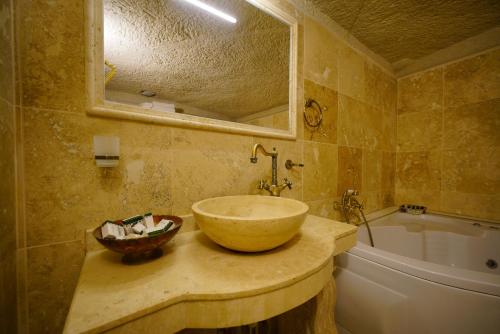a bathroom with a bowl sink and a tub at Vezir Cave Suites in Goreme