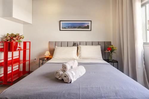 1 dormitorio con 1 cama con toallas en Apartamento Glória, en Río de Janeiro