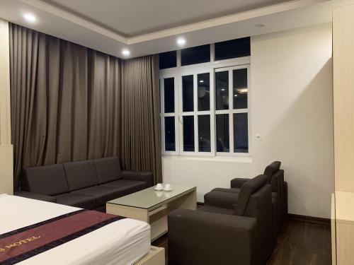 ein Schlafzimmer mit einem Bett, einem Sofa und einem Tisch in der Unterkunft Khách Sạn Tom’s in Thái Nguyên