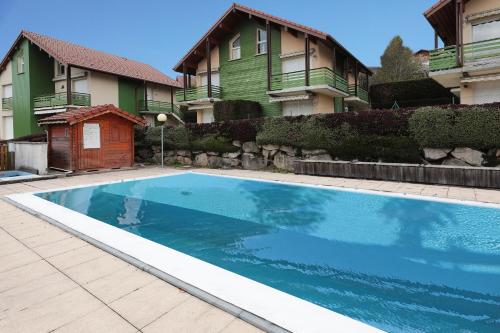 une piscine devant une maison dans l'établissement Domaine des Chênes Rouges - Appt 3 étoiles pour 4p dans chalet, à Gérardmer