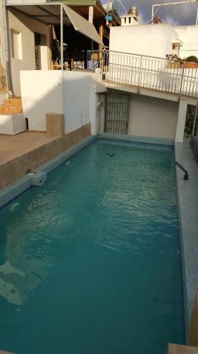uma piscina de água azul em frente a um edifício em Riad marco andaloz em Salé
