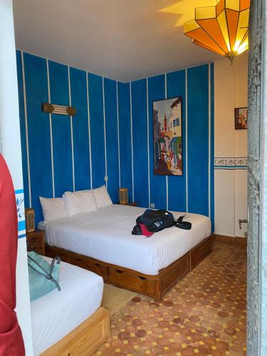 two beds in a room with blue walls at Riad marco andaloz in Sale