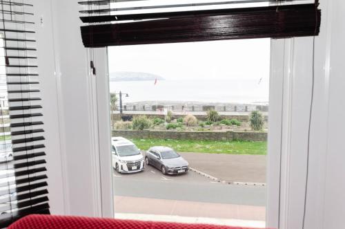 a window with two cars parked in a parking lot at Opul Boutique at Admiral House in Douglas