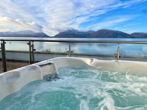 a hot tub with a view of the water at Beach Houses with Hot Tubs in Glencoe