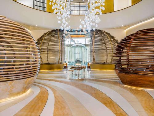 hol z korytarzem z żyrandolem i budynkiem w obiekcie Fairmont Doha w mieście Doha