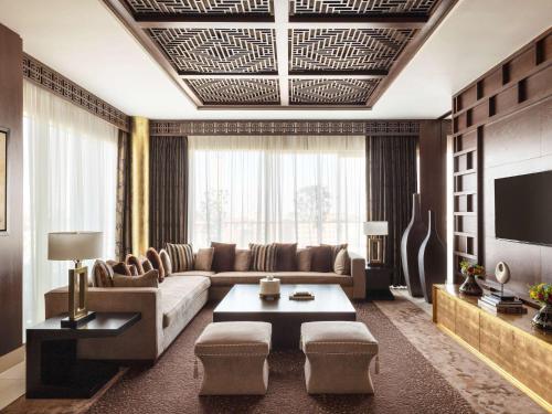 a living room with a couch and a tv at Raffles Dubai in Dubai
