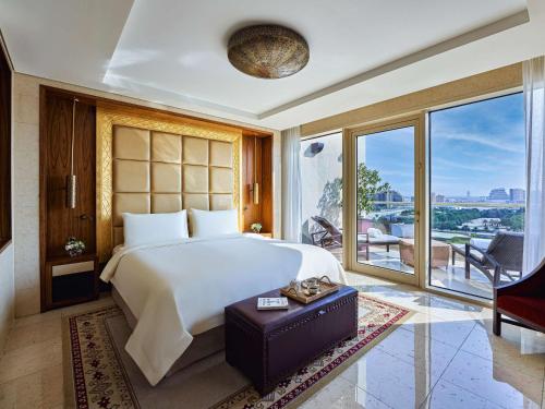 una camera con un grande letto e una grande finestra di Raffles Dubai a Dubai