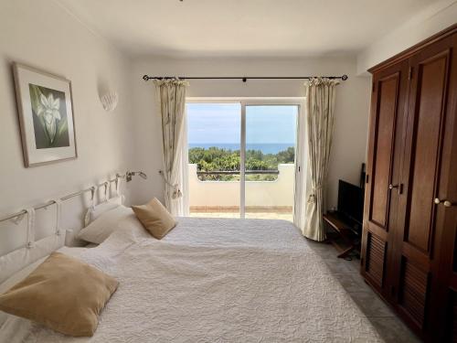 una camera da letto con un letto e una grande finestra di 233 Galo Verde Apartment, 2 Schlafzimmer a Benagil