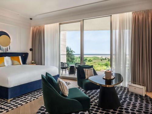 a hotel room with a bed and a large window at Sofitel Cotonou Marina Hotel & Spa in Cotonou