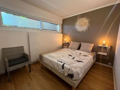 une chambre avec un lit, une chaise et une fenêtre dans l'établissement Le Plein Sud, à Bandol