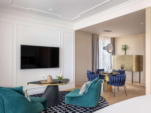 a living room with blue chairs and a table at Sofitel Cotonou Marina Hotel & Spa in Cotonou