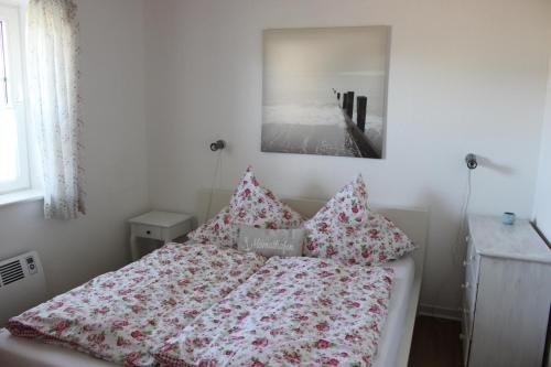 a bedroom with a bed with pillows on it at Ferienhaus Meerzeit in Nordstrand