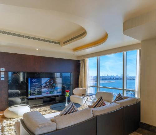 a living room with a large couch and a tv at The Art Hotel & Resort in Manama