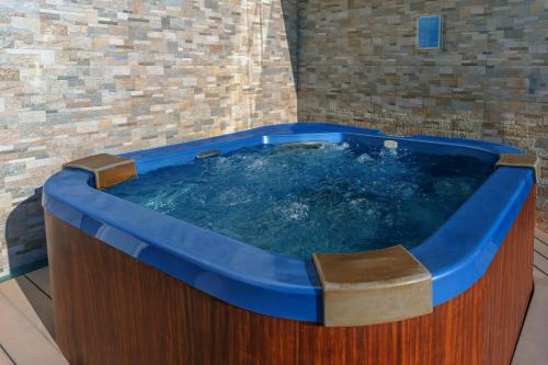 a jacuzzi tub in a room with a brick wall at The Art Hotel & Resort in Manama