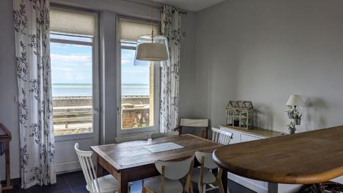 une salle à manger avec une table et une vue sur l'océan dans l'établissement LES TAMARIS, Villa face à la mer, emplacement privilégié, à Veulettes-sur-Mer
