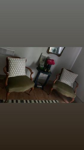 two chairs in a room with a table and a window at La Maison Ancienne Eymet in Eymet