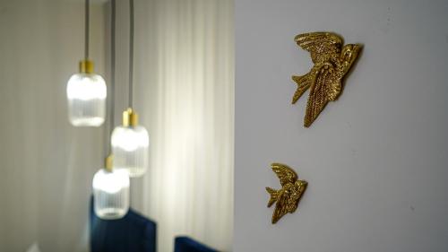 two gold starfish decorations on a wall with lights at Apartamentos Puente Romano Suites Parking Gratis in Merida