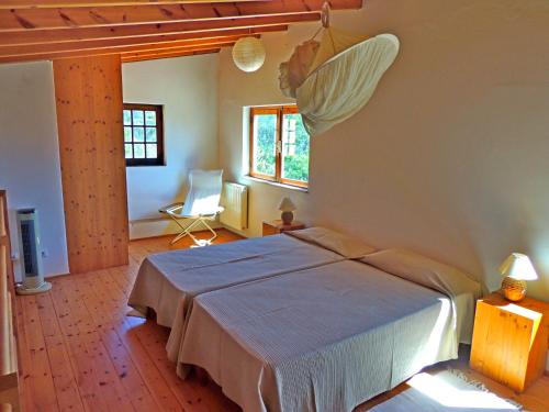 a bedroom with a bed and a chair in a room at Casa dos Sonhos, private terrace, quiet location, walking to village, ecological pool, pets considered, nature friendly in Barão de São João