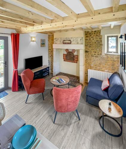 un salon avec un canapé et une cheminée dans l'établissement Escapade Bucolique à Bayeux, à Cussy