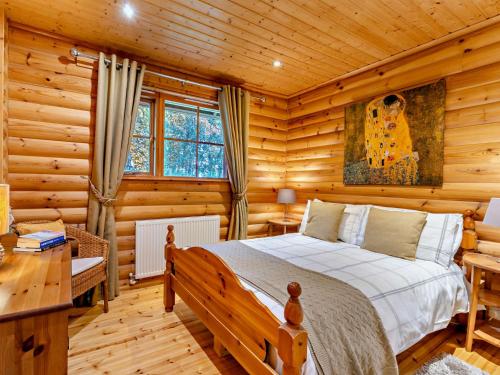 a bedroom with a bed in a log cabin at 3 Bed in Peebles LK15M in Walston