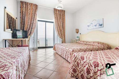 Pokój hotelowy z 2 łóżkami i balkonem w obiekcie HOTIDAY Hotel Cefalù w Cefalù