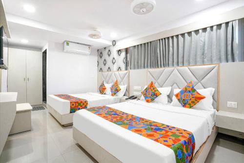 a hotel room with two beds and a television at FabHotel Grey Sky in Gandhinagar