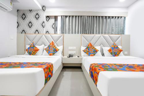 a bedroom with two beds with colorful sheets at FabHotel Grey Sky in Gandhinagar