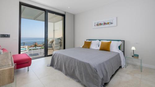 Un dormitorio con una cama y vista al mar. en VILLA SABBIE ROSSE 6, Emma Villas, en Ovile la Marinella