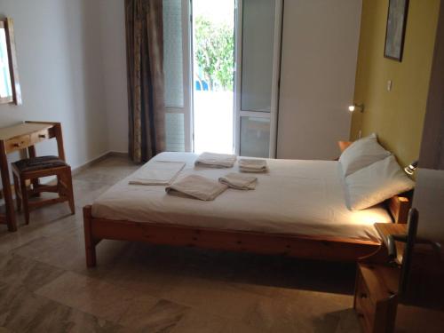 a bedroom with a bed with towels on it at Family sea view apartment near the beach in Makry Gialos