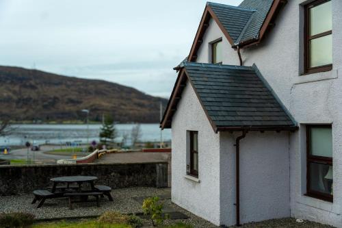 a picnic table next to a building with a table at Rockvale Cottage in Fort William