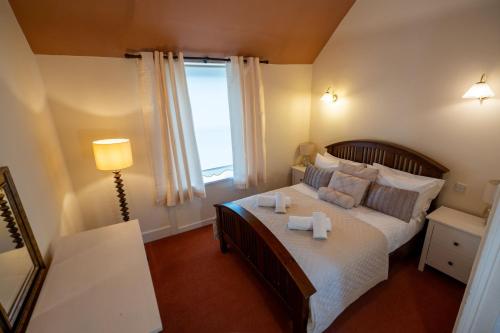 a bedroom with a large bed with two towels on it at Rockvale Cottage in Fort William
