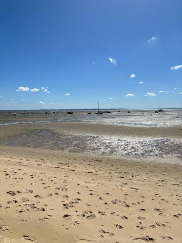 a beach with footprints in the sand and the ocean at Azurea - Charmant appartement à Andernos-les-Bains in Andernos-les-Bains