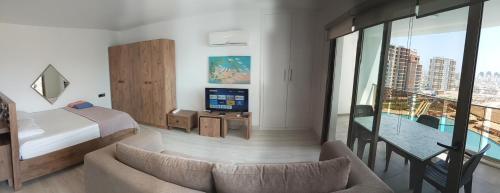 a hotel room with a bed and a couch and a tv at Iskele Long Beach, Aquapark tesisinde stüdyo daire in Famagusta