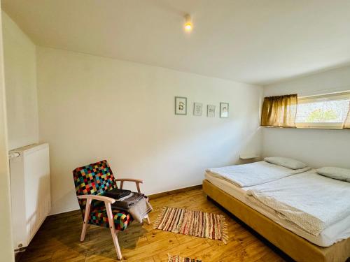 a small bedroom with a bed and a chair at Design Apartaments in Ostrów Wielkopolski