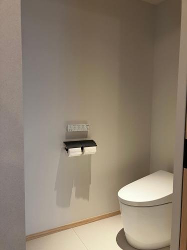 a bathroom with a toilet and a clock on the wall at 香雲閣kounkaku villa in Myoko