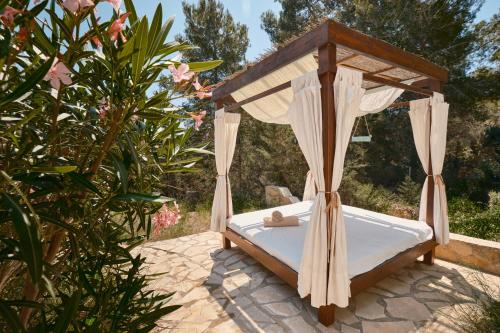 a bed with a canopy in a garden at Villa B&M Experience in Sant Francesc de s'Estany