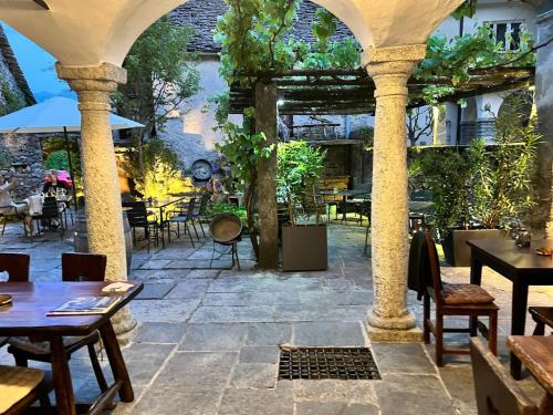 un patio al aire libre con mesas y sillas en un restaurante en B&B ALLA PIAZZETTA DI TEGNA en Tegna