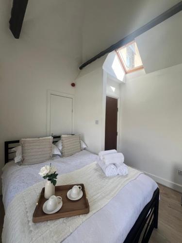 a bedroom with a bed with a tray of towels at Tynwald Apartments in Douglas