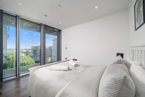 1 dormitorio blanco con 1 cama grande y ventanas grandes en Cosy 1 Bed apartment in Tower Hill, en Londres