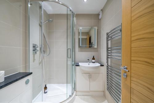 La salle de bains est pourvue d'une douche en verre et d'un lavabo. dans l'établissement Great flat near St Paul’s Cathedral, à Londres