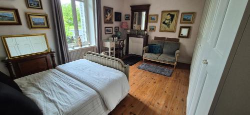 a bedroom with a bed and a chair in a room at Demeures ressourçantes - Le Vallon in Saint-Martin-de-Saint-Maixent