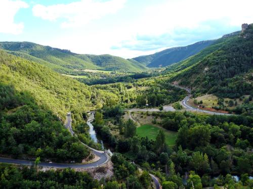 une vue aérienne sur une route sinueuse dans les montagnes dans l'établissement Gites Castel de Cantobre - L'Egyptien, à Cantobre